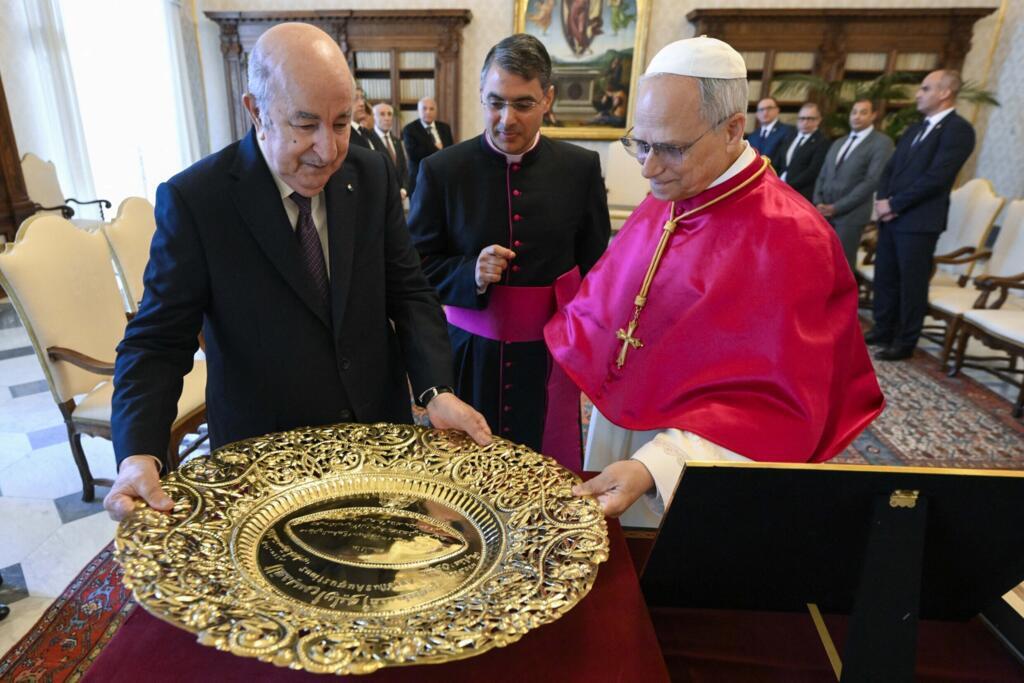 Cette photo prise le 24 juillet 2025 et publiée par le service de presse du Vatican, Vatican Media, montre le pape Léon XIV (à droite) recevant un cadeau du président algérien Abdelmadjid Tebboune, lors d'une audience privée au Vatican. Le président algérien a offert au pape un rameau d'olivier d'un arbre planté par Saint Augustin en Algérie.