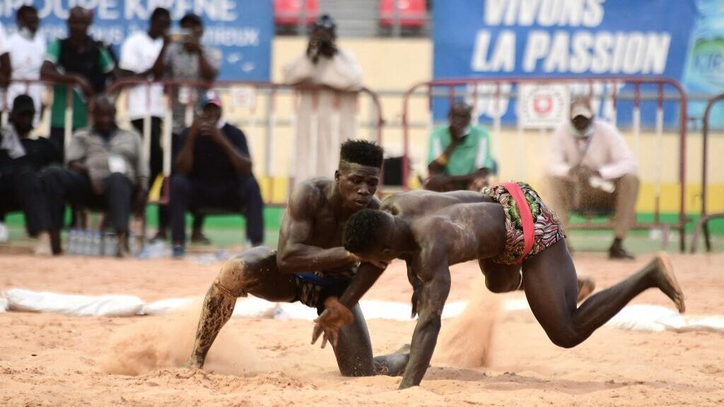 Un lutteur sénégalais (à droite) affronte un Gambien dans un combat à l'arène nationale de Pikine, en banlieue de Dakar.