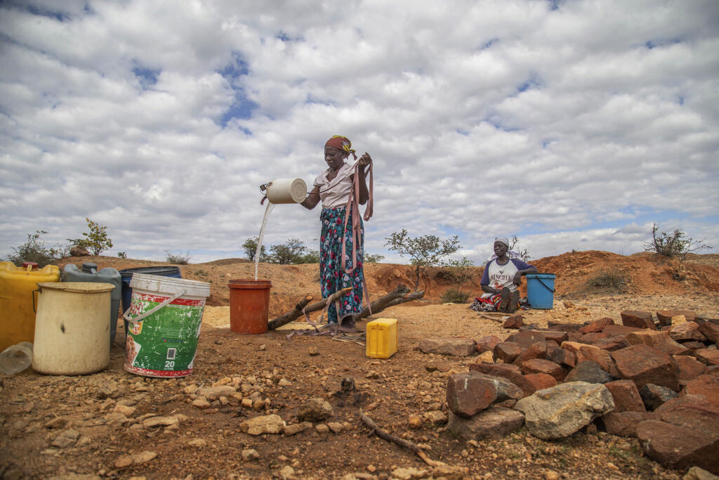 Des villageois vont chercher de l'eau dans un puits de fortune à Mudzi, au Zimbabwe, le 2 juillet 2024.