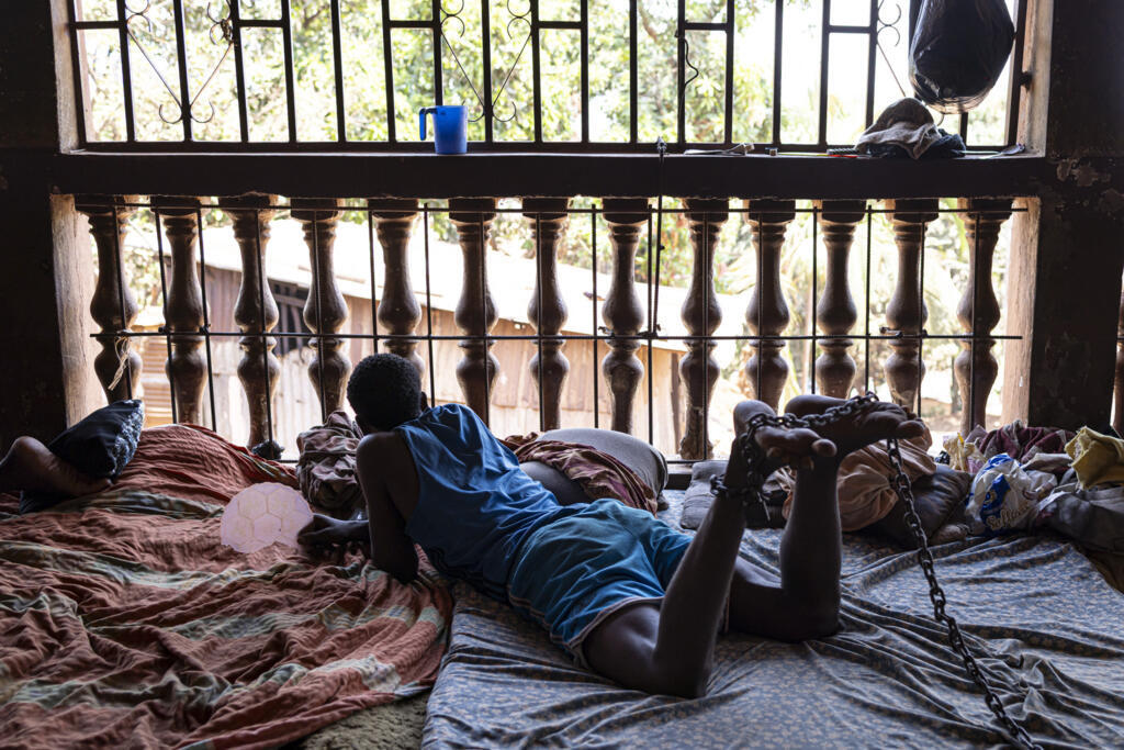 Un patient enchaîné regarde dehors dans un centre de rééducation informel situé dans la banlieue de Freetown, le 26 avril 2025.
