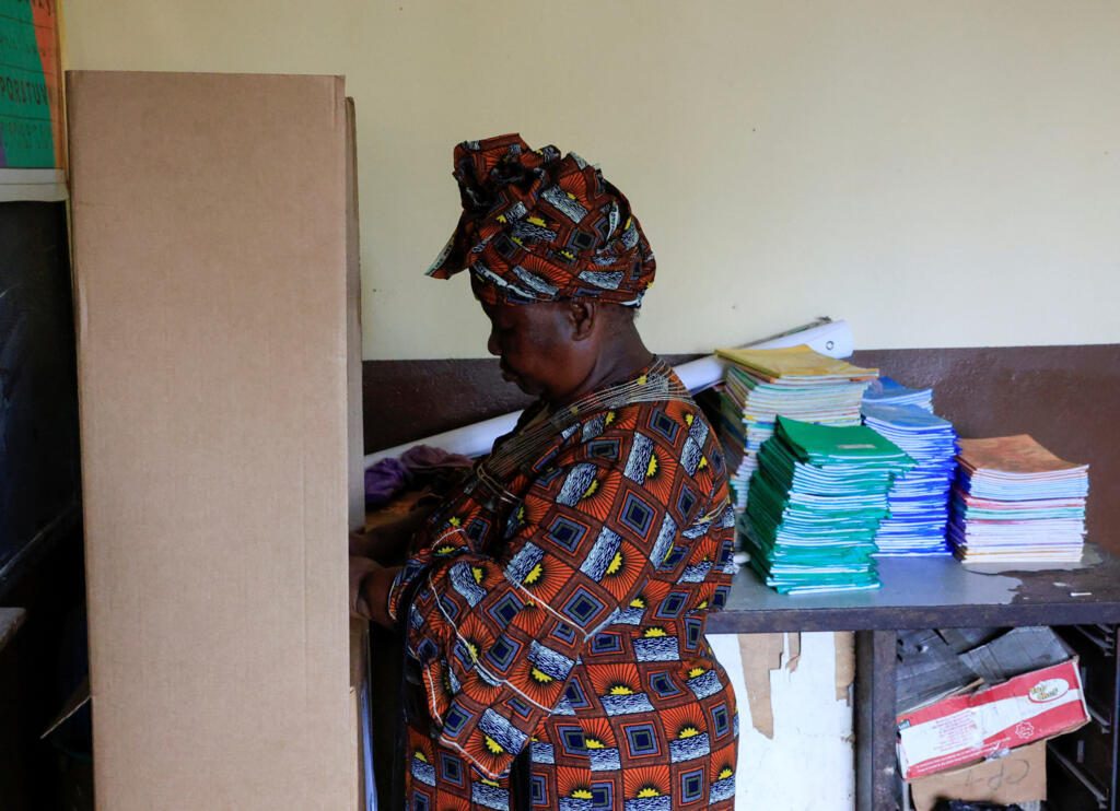 Une femme se prépare à voter lors de l'élection présidentielle, dans un bureau de vote à l'intérieur d'une école, à Abidjan, en Côte d'Ivoire, le 25 octobre 2025.