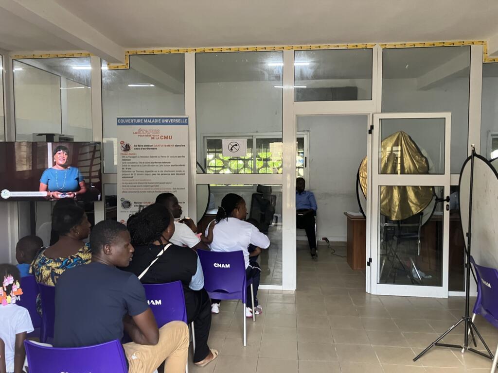Une vingtaine de personnes faisant la queue dans un centre d'enrôlement de la CMU, dans la commune de Bingerville, à Abidjan.