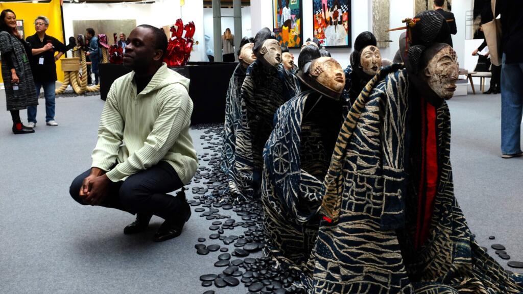 L’artiste et designer camerounais Serge Mouangue devant « Seven Sisters », une des quatre sculptures de son œuvre monumentale, « La troisième esthétique », à AKAA 2025, Paris.