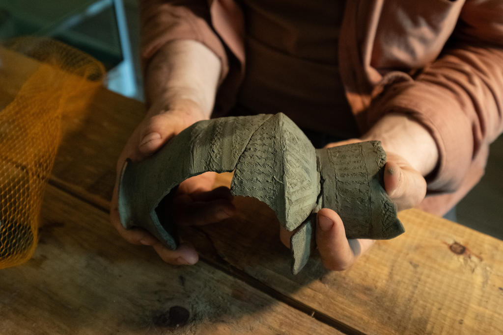 Remontage en cours d’une bouteille en céramique de type qulal.