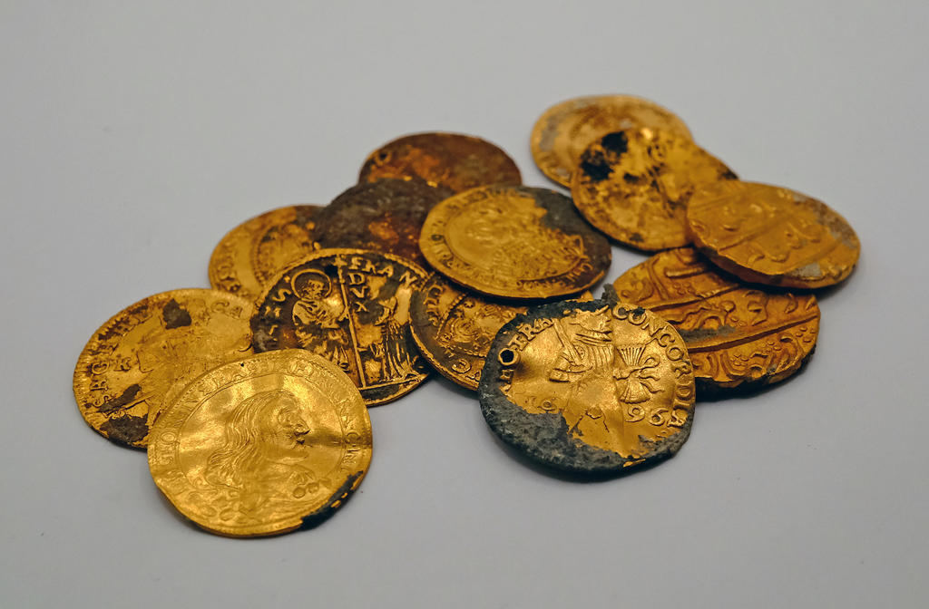 Treize des quatorze pièces de monnaie en or découvertes sur l’épave, datées entre 1654 et 1713. Sept ducats de Venise, deux ducats des Provinces-Unies (Pays-Bas), trois frappés dans le Saint Empire (Allemagne et Hongrie) et deux mohurs venant de l’Empire moghol (Inde).