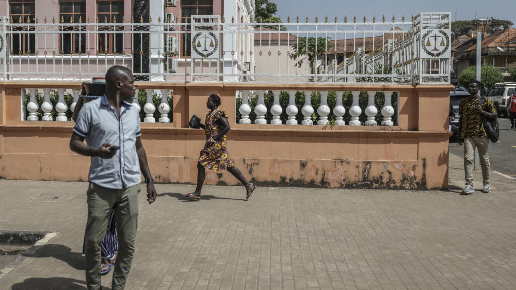 Une femme prend la fuite alors que des coups de feu retentissent près du palais présidentiel de Bissau le 26 novembre 2025.