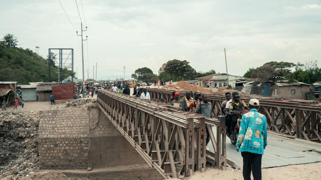 Des motos et des piétons traversent un pont à Uvira le 9 décembre 2025.