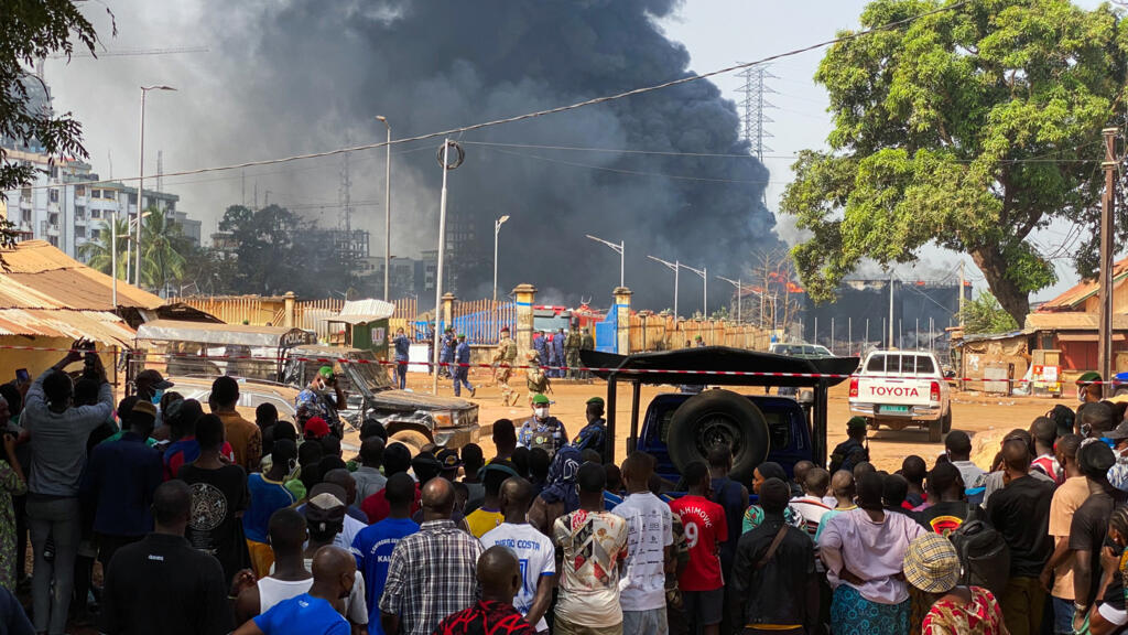 Des personnes observent le site de l'explosion depuis l'arrière de la barrière de sécurité après l'explosion d'un terminal pétrolier à Conakry, en Guinée, le 19 décembre 2023. (Image d'illustration)