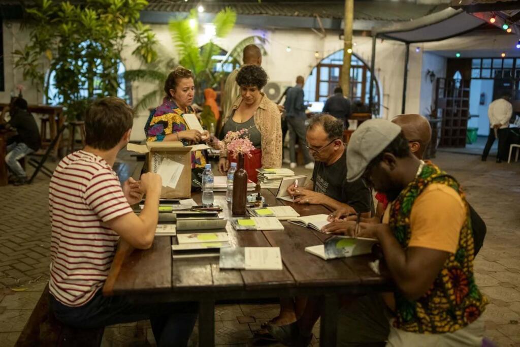 Patrick Singh et Patrick Bebey en pleine signature lors du lancement en Tanzanie de « Kusadikika ».