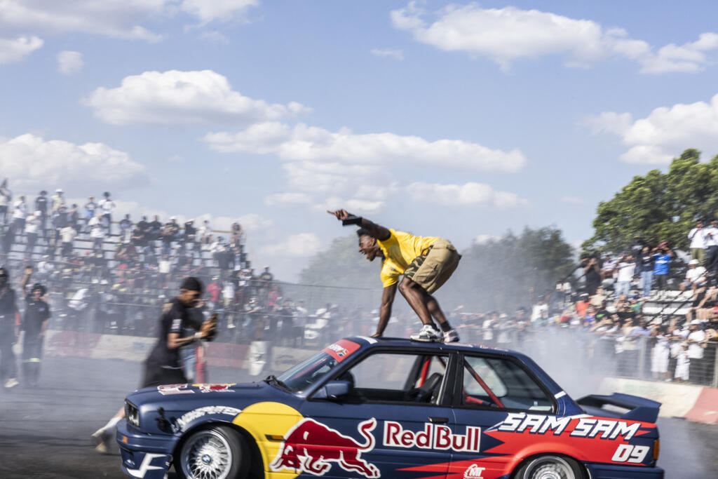 Le YouTuber et streamer américain Darren Jason Watkins Jr, plus connu sous le nom d'IShowSpeed (C), s'accrochant au toit de la voiture de Samkeliso Samsam Thubane, également connu sous le nom de Sam Sam et athlète officiel de Red Bull, dans le sud de Johannesburg, le 2 janvier 2026.