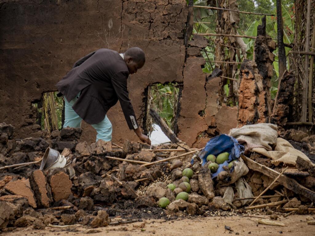 Deogratias Kasereka, chef du village de Mukondi, fouille les vestiges d’une maison incendiée lors d’une attaque attribuée aux ADF à Mukondi, à environ 30 kilomètres de la ville de Beni, dans l’est de la République démocratique du Congo, le 10 mars 2023.