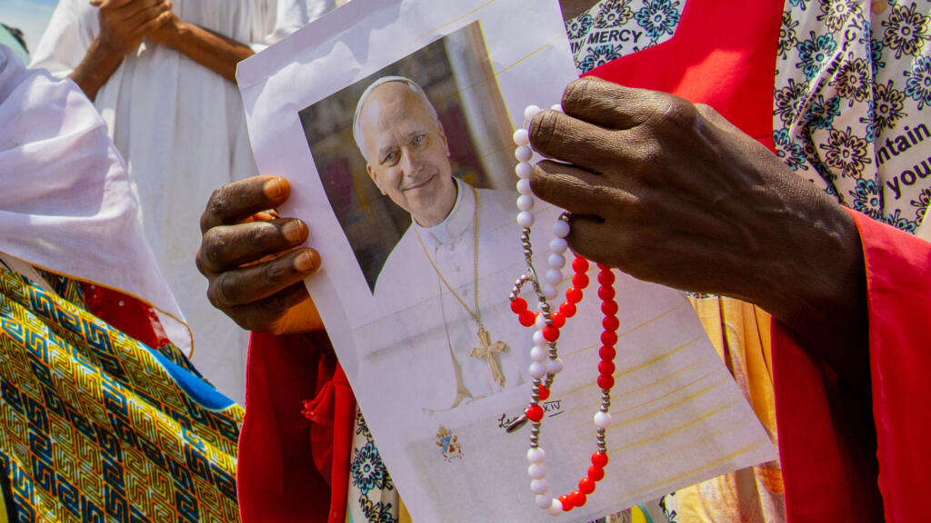 Une fidèle catholique tient une image du pape Léon XIV en attendant son arrivée à l'aéroport international de Yaoundé Nsimalen, au Cameroun, le mercredi 15 avril 2026.